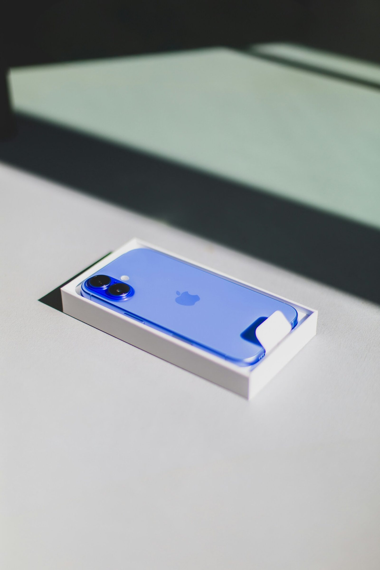 A blue iPhone sitting on top of a white table